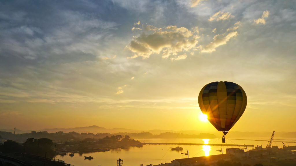 Hot-air balloon at sunrise over a tank